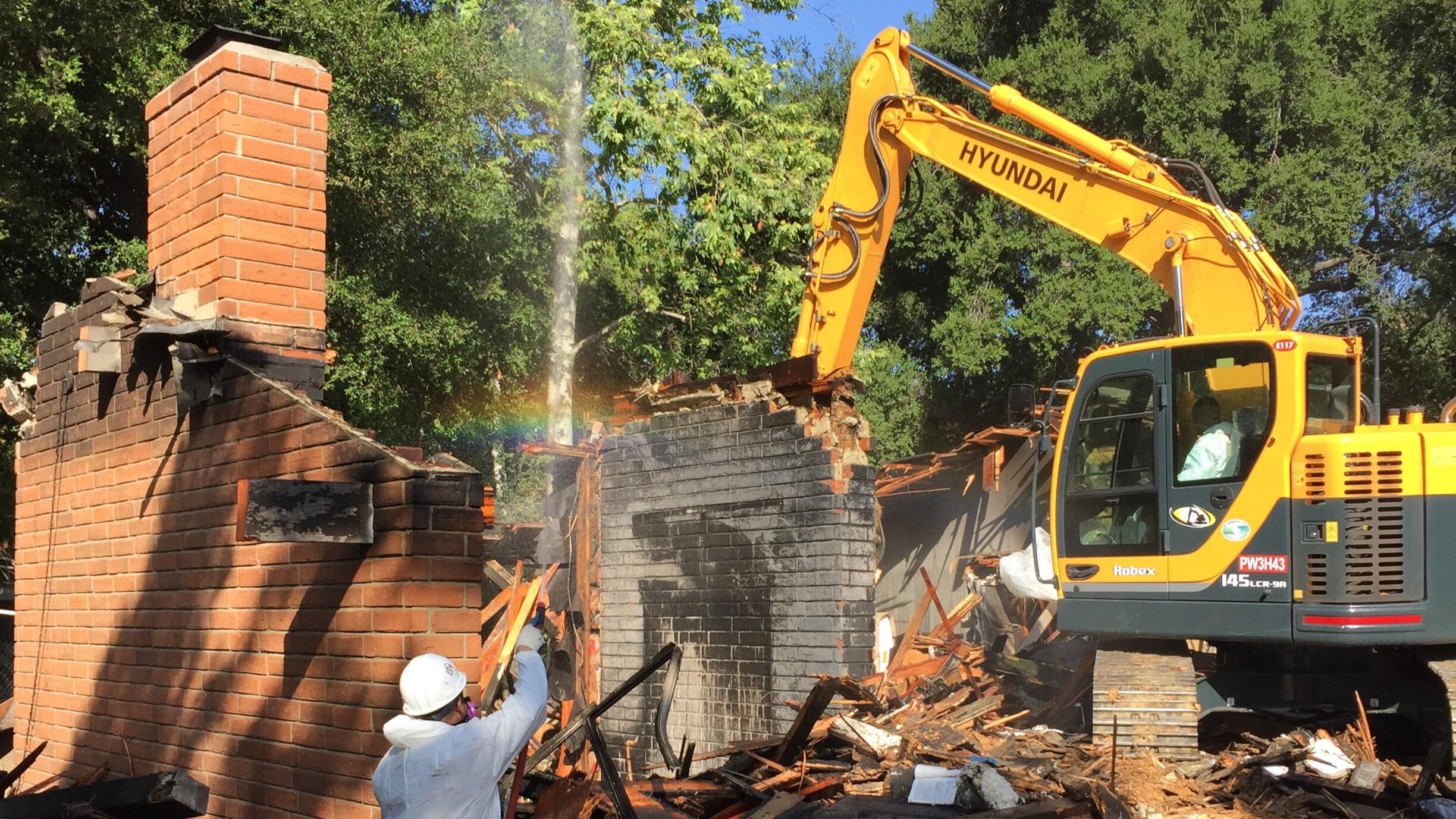 Demolition of a house to prepare for new construction. Rainbow.