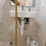 Measuring sink mounting height for ADA compliance.