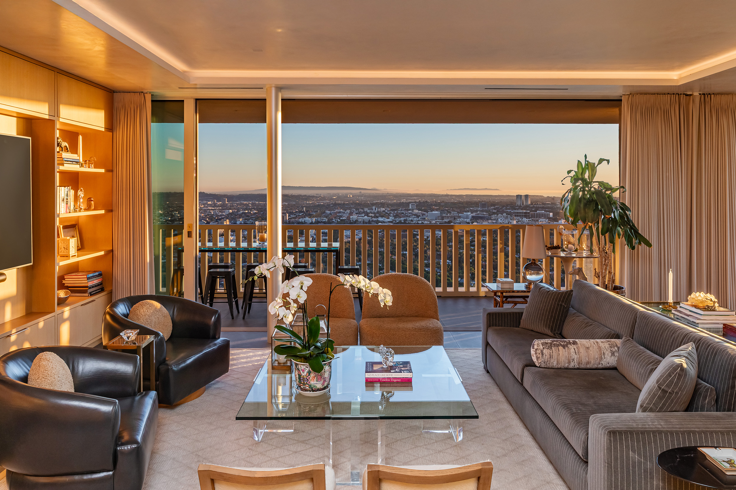 Living Room in West Hollywood apartment by Hayne Architects featuring venetian plaster ceiling, large format tile and full-height sliding glass doors.