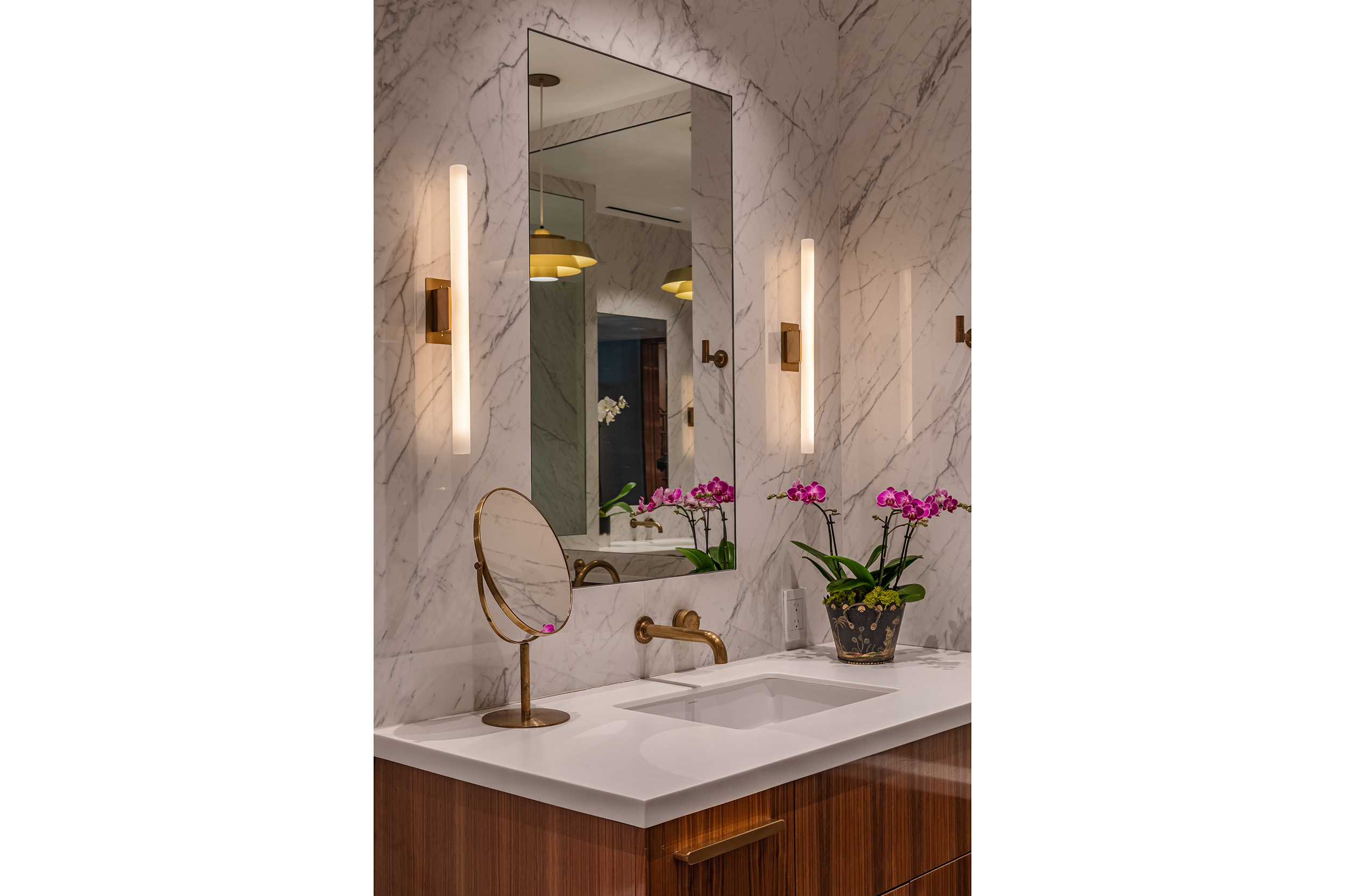 Bathroom in West Hollywood apartment by Hayne Architects featuring walnut cabinetry, Laminam Statuarietto countertops and walls.