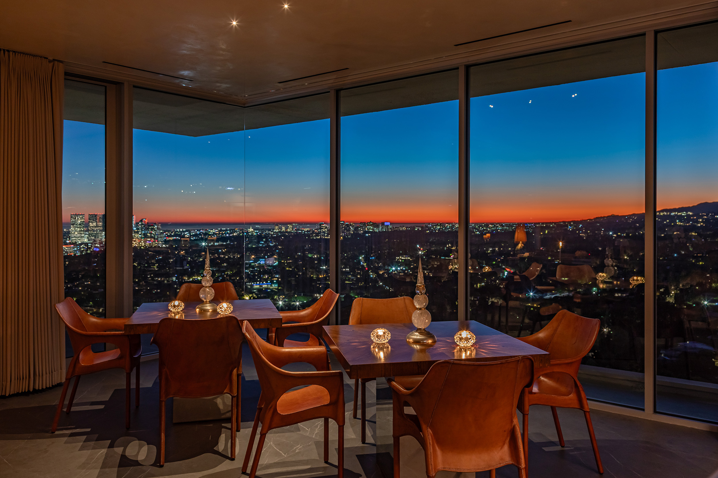 Dining Room in West Hollywood apartment by Hayne Architects featuring venetian plaster ceiling, large format tile and full-height glass corner with city views.